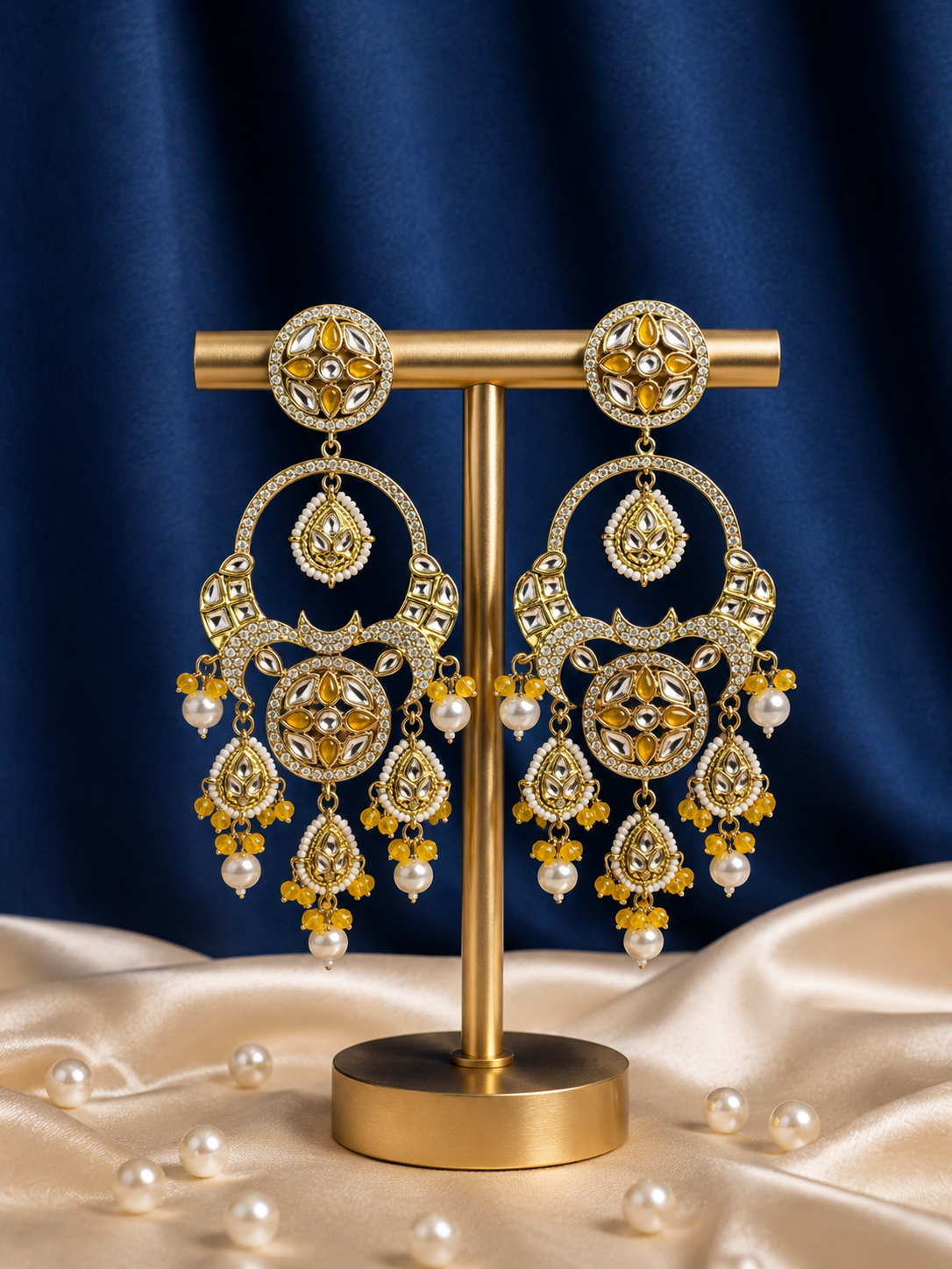 Sonakshi yellow Kundan chandbali earrings with pearl drops and hanging motifs.