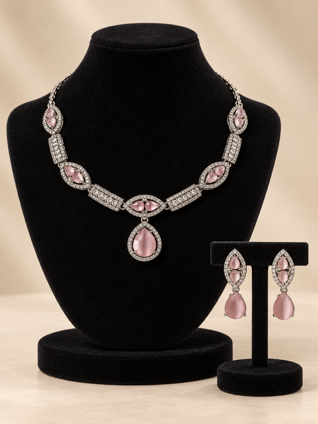 Jessica light pink American Diamond necklace with a teardrop pendant and matching drop earrings on a cream display bust