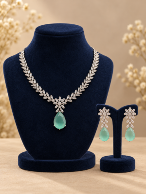 Sabha American diamond necklace and earrings with mint green teardrop accents on navy velvet stands