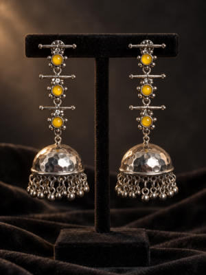 Triveni yellow stone oxidised silver-tone jhumka earrings with textured domes and dangling beads on a black velvet stand