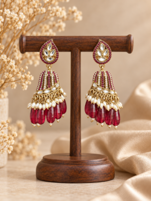 Chitra wine jhumka earrings with teardrop tops, gold-tone domes, white bead accents and dangling wine-coloured beads